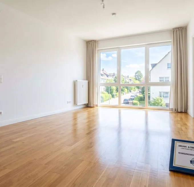 Strahlend sauberes, leeres Wohnzimmer in der alten Wohnung, bereit für die stressfreie Übergabe dank Abgabegarantie